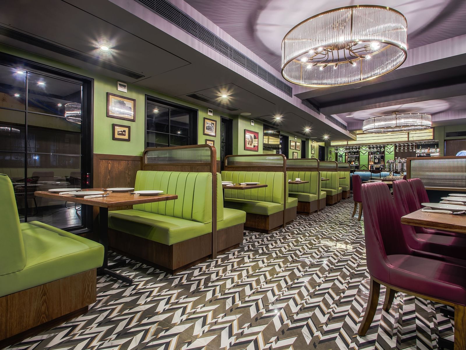 A retro-themed restaurant with green and purple booths, a tiled floor, and vintage-style lighting. 